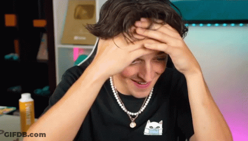 A Man Wearing A Pearl Necklace And A Black Shirt With A Cat On It GIF