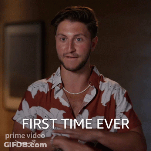 A Man Wearing A Pearl Necklace And A Shirt That Says First Time Ever GIF