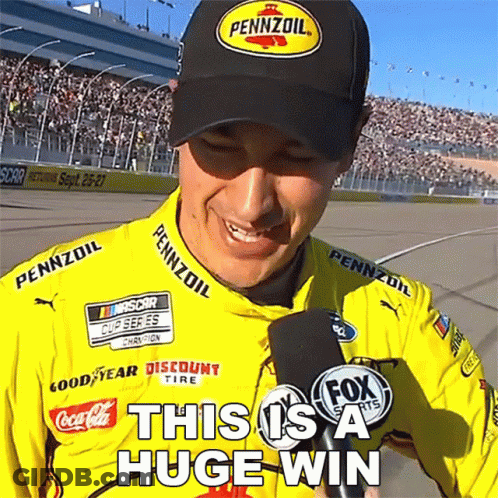 A Man Wearing A Pennzoil Hat Is Smiling While Holding A Microphone GIF