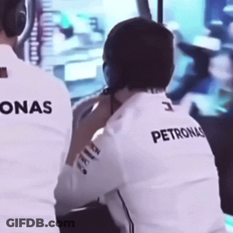 A Man Wearing A Petronas Shirt Is Sitting In Front Of A Monitor GIF