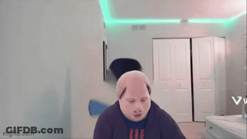 A Man Wearing A Pig Mask Is Standing In A Room With A Green Light On The Ceiling . GIF