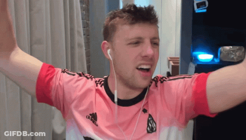 A Man Wearing A Pink Adidas Shirt With Ear Buds GIF