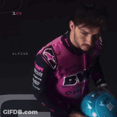 A Man Wearing A Pink And Black Shirt That Says Bwt Holds A Blue Helmet GIF