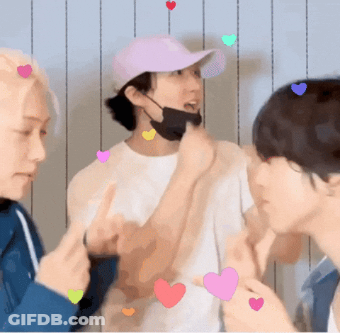 A Man Wearing A Pink Hat And A Black Mask Is Surrounded By Hearts . GIF