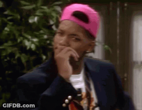 A Man Wearing A Pink Hat And A Jacket Is Covering His Mouth With His Hand . GIF