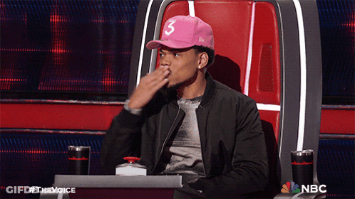 A Man Wearing A Pink Hat With The Number 3 On It Sits In A Chair GIF
