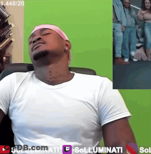 A Man Wearing A Pink Headband Sits In Front Of A Green Screen That Says Sollumini GIF