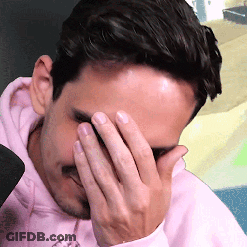A Man Wearing A Pink Hoodie Covering His Face With His Hand GIF