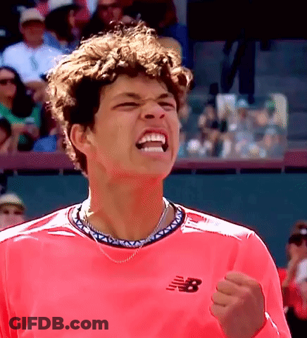 A Man Wearing A Pink New Balance Shirt Is Celebrating GIF