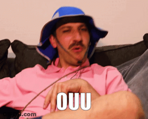 Man In Pink Shirt And Blue Ouu Hat GIF