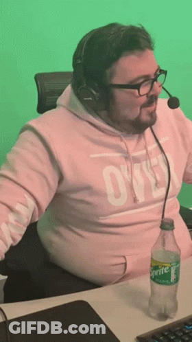 A Man Wearing A Pink Sweatshirt With The Word Ovo On It Sits At A Desk With A Sprite Bottle In Front Of Him GIF