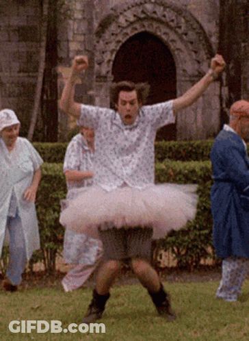 A Man Wearing A Pink Tutu Is Standing In The Grass GIF
