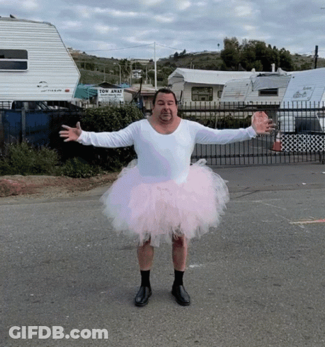 A Man Wearing A Pink Tutu Stands In Front Of A Tow Away Sign GIF