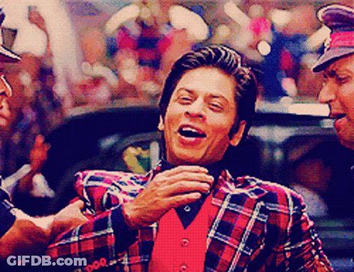 A Man Wearing A Plaid Jacket And A Red Vest Laughs GIF