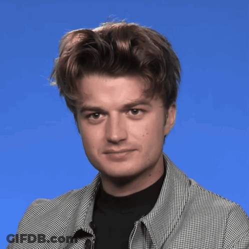 A Man Wearing A Plaid Jacket And Black Shirt Is Making A Face GIF