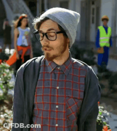 A Man Wearing A Plaid Shirt And A Beanie Looks Down GIF