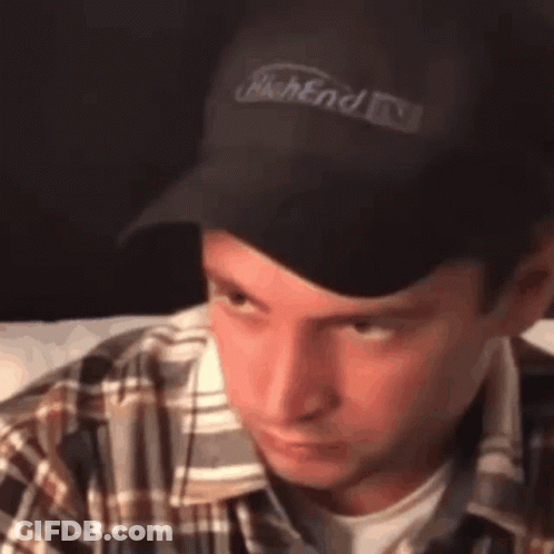 A Man Wearing A Plaid Shirt And A Black Hat With The Word Weekend Written On It GIF
