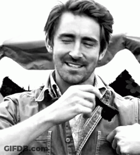 A Man Wearing A Plaid Shirt And A Denim Jacket Is Smiling With His Eyes Closed GIF