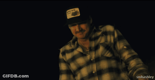 A Man Wearing A Plaid Shirt And A Hat That Says Little Rock City On It GIF