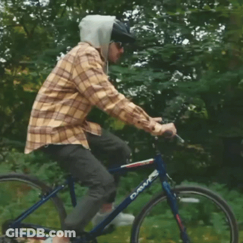 A Man Wearing A Plaid Shirt And A Helmet Is Riding A Dawes Bike GIF