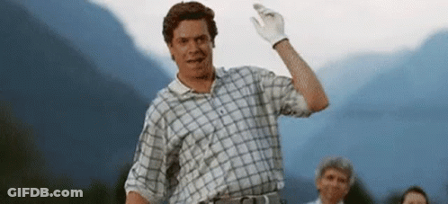 A Man Wearing A Plaid Shirt And White Gloves Is Waving His Hand . GIF