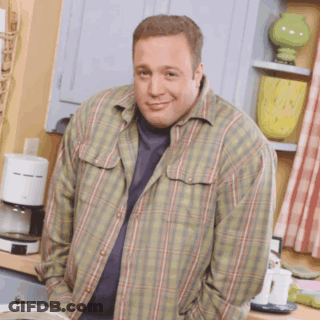 A Man Wearing A Plaid Shirt Is Standing In A Kitchen With His Hands In His Pockets GIF