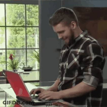 A Man Wearing A Plaid Shirt Is Typing On A Laptop GIF