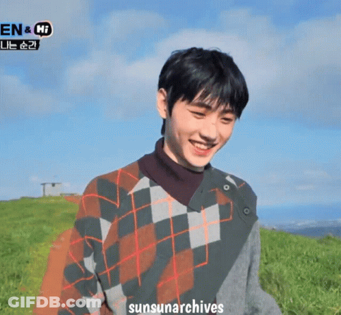 A Man Wearing A Plaid Sweater Is Smiling In A Field With The Words Sunsunarchives Written Below Him GIF