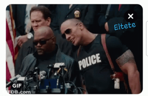 A Man Wearing A Police Shirt Is Standing In Front Of A Crowd GIF