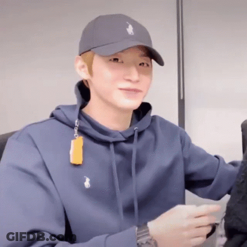 A Man Wearing A Polo Hat And A Blue Hoodie Is Smiling GIF