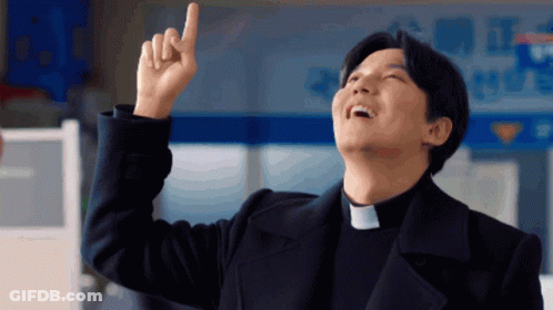 A Man Wearing A Priest Collar Points Upwards With His Finger GIF