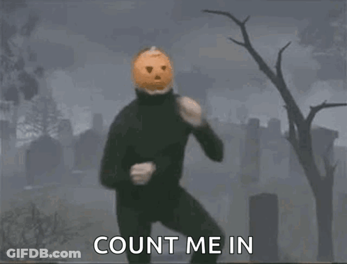 A Man Wearing A Pumpkin Mask Is Dancing In A Cemetery . GIF