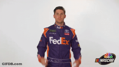 A Man Wearing A Purple And Orange Fedex Racing Suit GIF