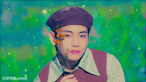 A Man Wearing A Purple Beret Is Holding A Flower GIF