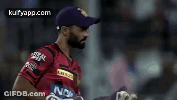 A Man Wearing A Purple Hat And A Red Shirt With A Noki Logo On It . GIF