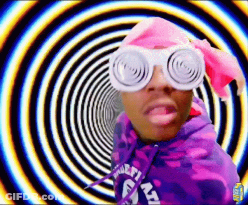 A Man Wearing A Purple Hoodie And White Glasses Is Standing In Front Of A Spiral . GIF