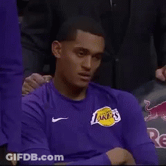 A Man Wearing A Purple Lakers Shirt Is Sitting In The Stands GIF