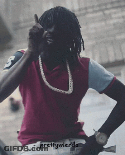 A Man Wearing A Purple Shirt And A Pearl Necklace Is Giving A Thumbs Up Sign GIF