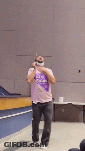 A Man Wearing A Purple Shirt That Says Link Arms GIF