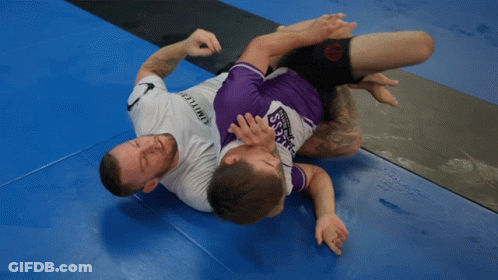 A Man Wearing A Purple Shirt That Says Samurai Is Wrestling Another Man GIF