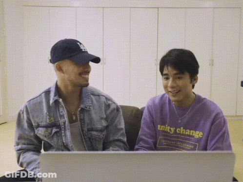 A Man Wearing A Purple Shirt That Says Unity Change Sits Next To Another Man GIF