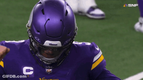 A Man Wearing A Purple Vikings Jersey With The Number 8 On It GIF