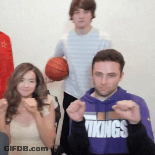 A Man Wearing A Purple Vikings Sweatshirt Is Making A Fist GIF