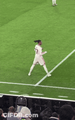 A Man Wearing A Qatar Airways Jersey Stands In Front Of A Red Wall GIF