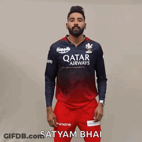 A Man Wearing A Qatar Airways Shirt And Red Pants Is Standing In Front Of A Wall . GIF