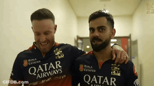 A Man Wearing A Qatar Airways Shirt Stands Next To Another Man GIF