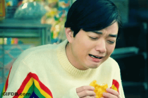 A Man Wearing A Rainbow Striped Sweater Is Eating A Waffle GIF