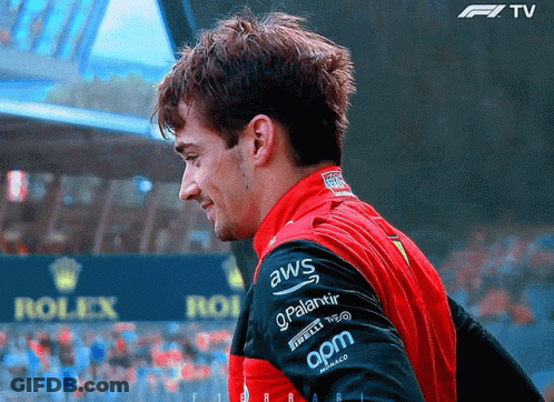 A Man Wearing A Red And Black Jacket With Aws On The Sleeve GIF