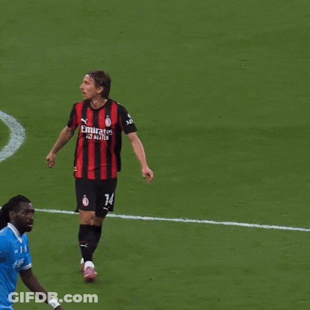 A Man Wearing A Red And Black Striped Shirt With Fly Emirates On The Front GIF