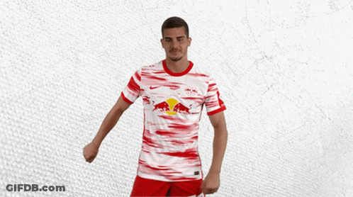 A Man Wearing A Red And White Jersey With A Bull On It GIF